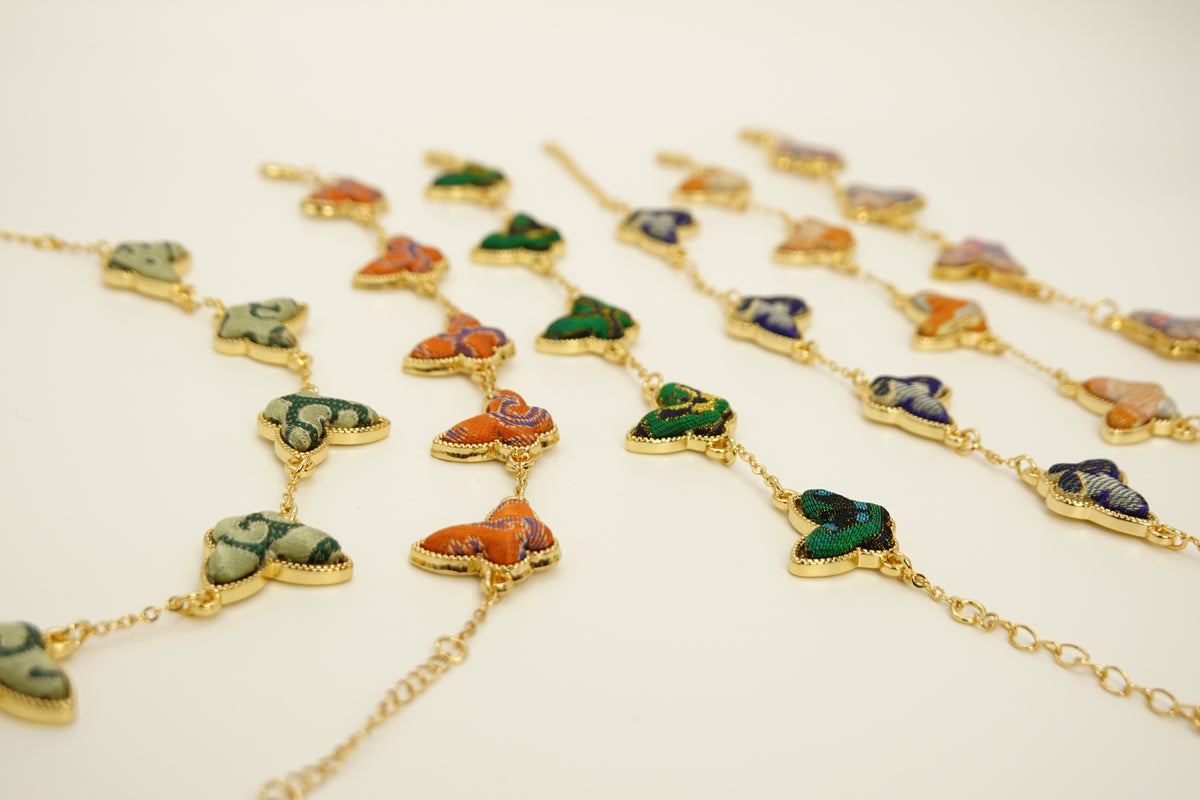 Close-up of silk butterfly bracelet colors and gold-tone chain